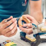 Hands of technician making denture